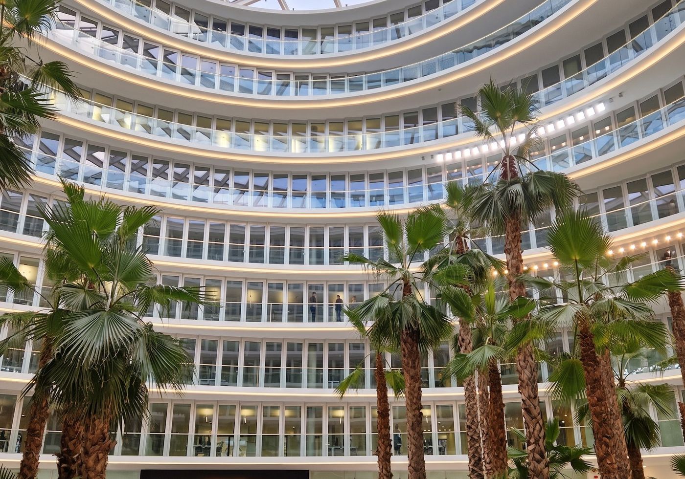 Fertiges Atrium eines Bürogebäudes mit umlaufenden Galerien und Palmen