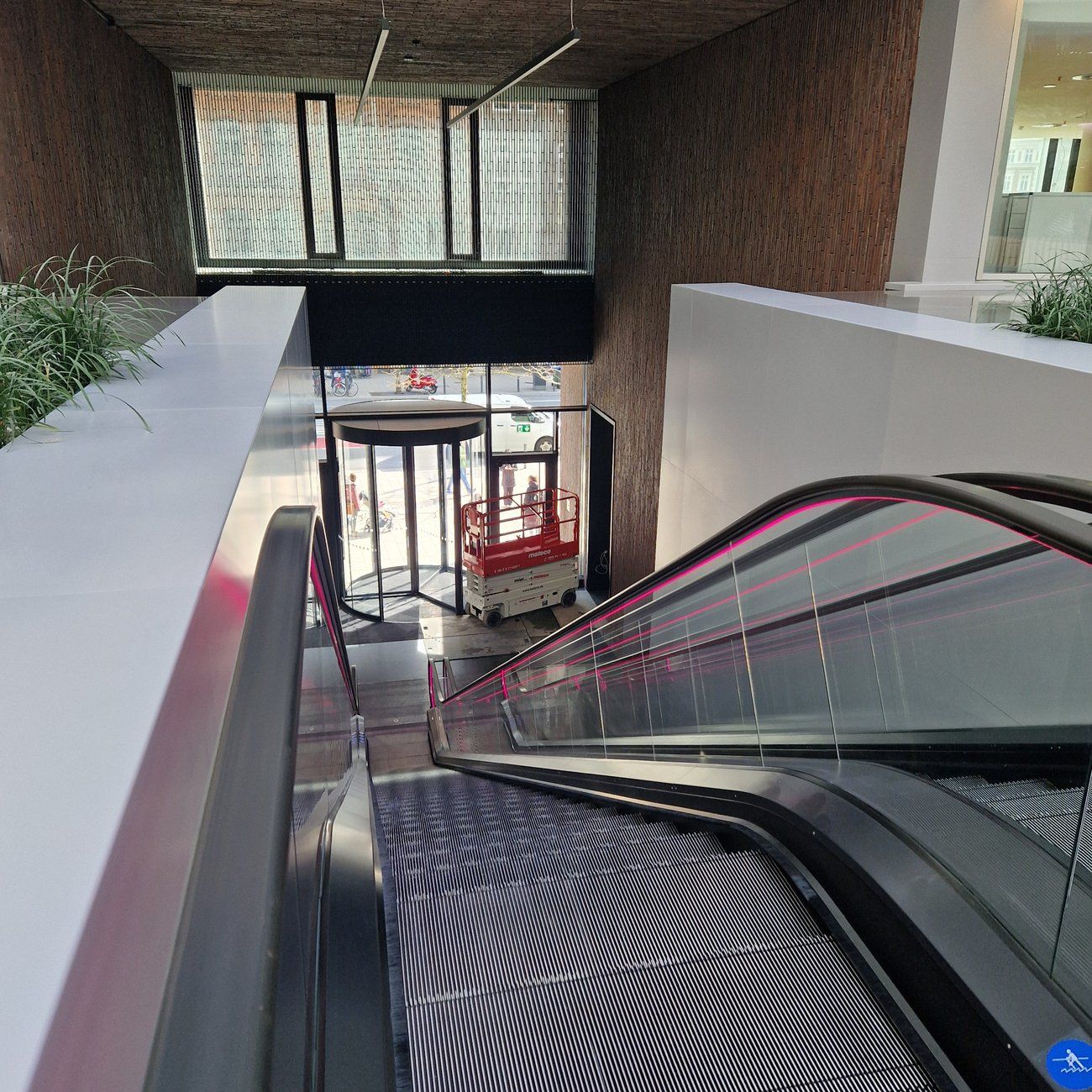 Eingangsbereich mit Empfangstresen, Rolltreppe und Karusselltür zur Straße
